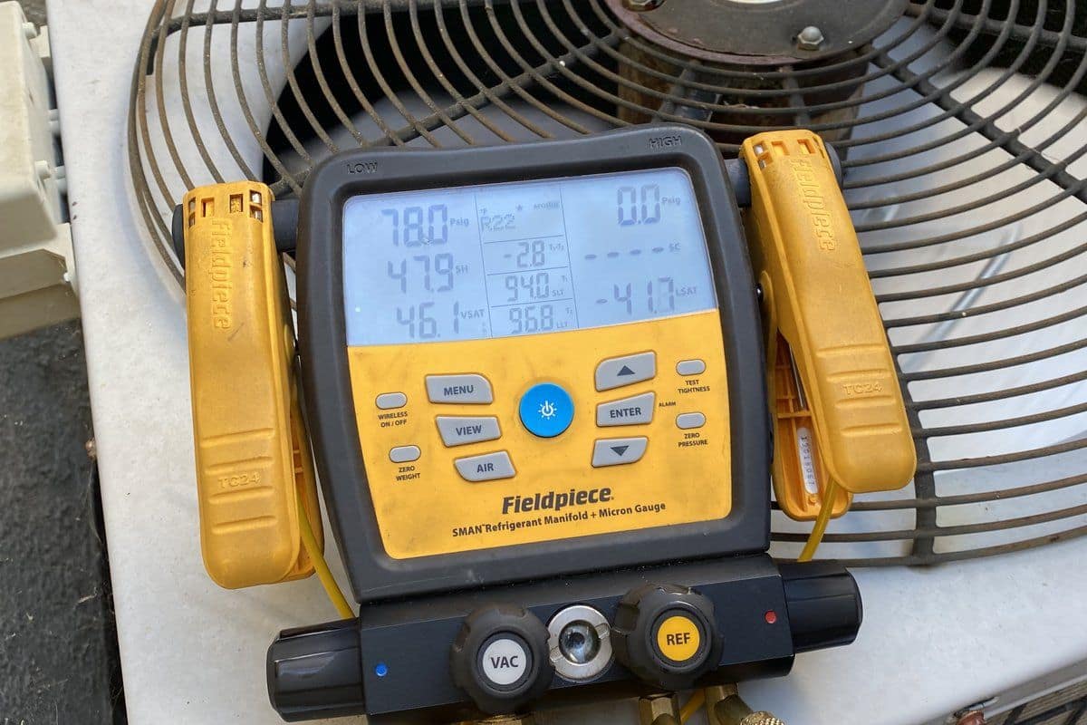 Aging residential air conditioning condenser unit installed alongside a home exterior wall