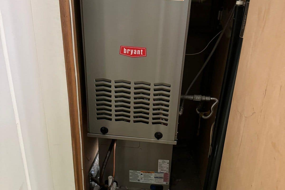 Outdoor heat pump unit covered in snow, illustrating cold-weather heating system failures